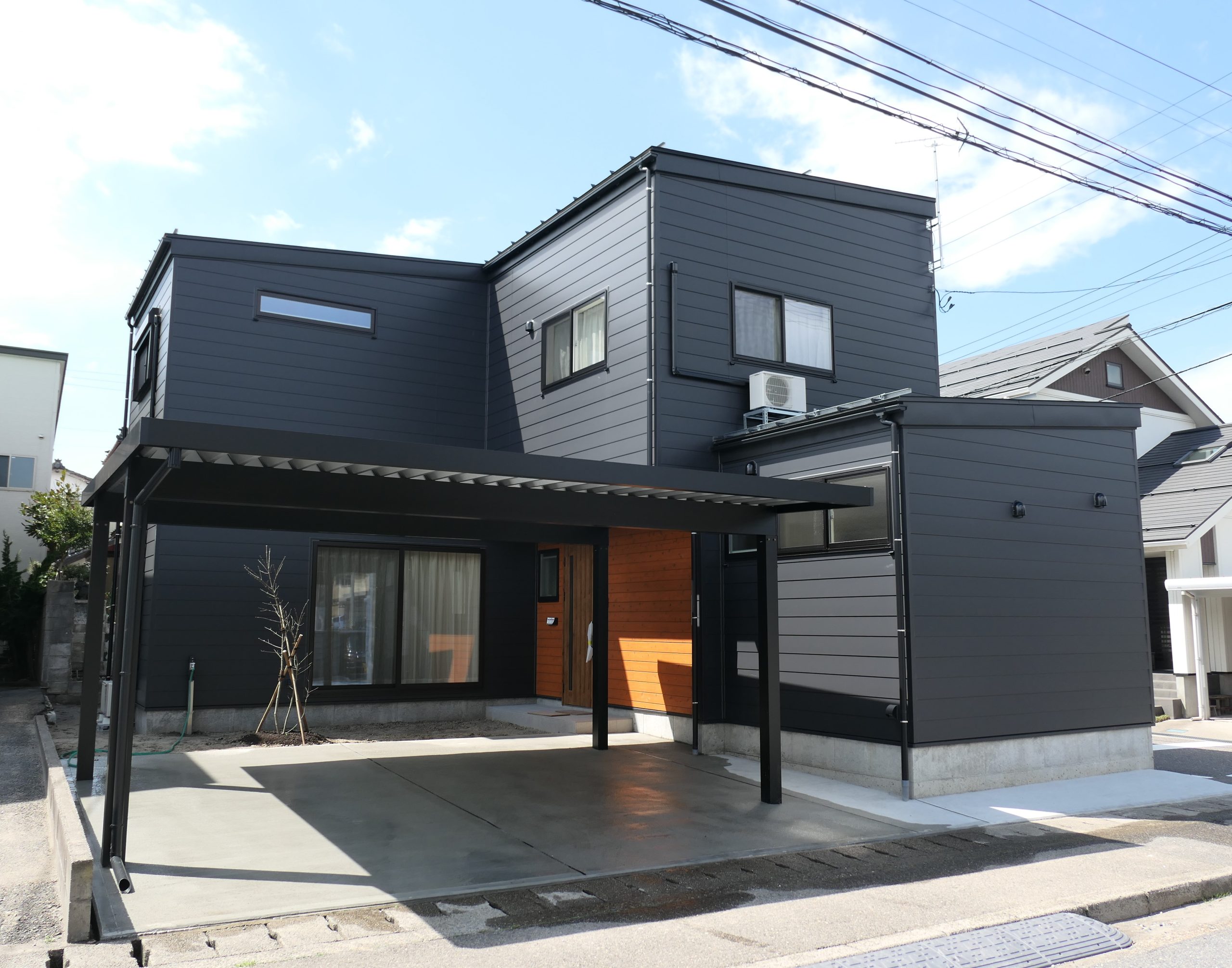 新潟の建売住宅tooneHOUSE（トーンハウス）黒い外壁のL字型の家と黒いカーポート